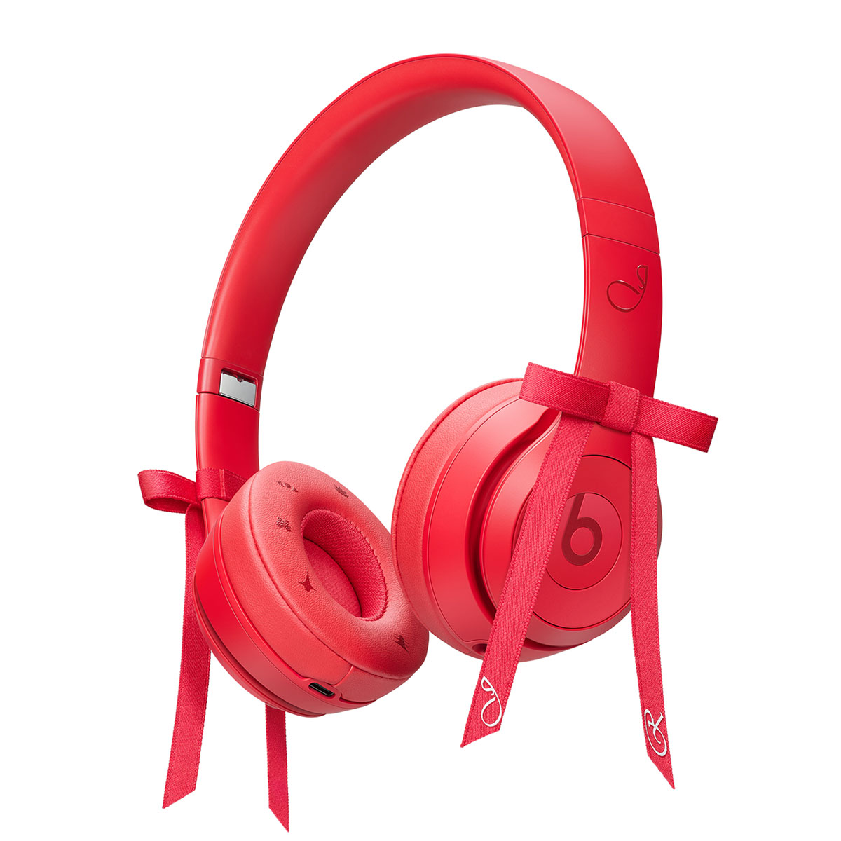Picture of Beats by Dre headphones in the color red with two decorative bow ties on each side of headphone.